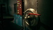 © icetray - A close up view of a metallic valve with a red lever located in a dark industrial area. The surrounding features various machinery and illuminated buttons, creating a high tech atmosphere.