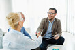 © Lumos sp - Portrait of a businessman or real estate agent or doctor shaking hands and signing a deal contract with senior couple in his office