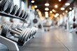 © whitestorm - Close-up of chrome dumbbells on a rack in a modern fitness gym interior.