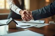 © miss irine - Two business partners shake hands over desk with miniature house documents. Represents successful real estate deal or agreement. Focus on partnership pro collaboration and trust in corporate finance.