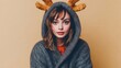 © tashechka - Festive young woman wearing reindeer antlers and a cozy sweater