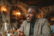 © Diana - a dark-skinned young man talking passionately during an interview or conversation. A man is sitting at a table in a cozy and stylish restaurant.