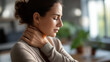 © Kateryna - Young woman's hand on inflamed neck area face partially hidden neck pain cervical discomfort muscle strain tension headache workplace injury stress related pain chronic