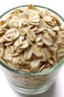 © Konstiantyn Zapylaie - Glass bowl filled with raw rolled oats on white background - whole grains and healthy eating