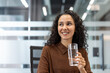 © Liubomir - Woman smiling while staying hydrated at her modern office desk, enjoying a refreshing glass of water and practicing self-care during a busy workday, healthy and positive