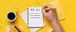 © Pixel-Shot - Male hand with to-do list, notebooks, cup of coffee and stationery on yellow background