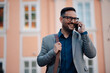 © Zamrznuti tonovi - Cheerful businessman talking on smartphone in city center