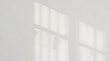 © Oleraj Hossin - Soft sunlight casting geometric shadows on a white wall