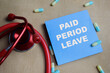 © syahrir - Concept of paid period leave write on sticky notes isolated on Wooden Table.