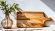 © aandd - Wood cutting board & vase, shadows on table against white wall