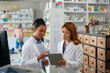© Drazen - Female pharmacists using digital tablet while working in pharmacy.