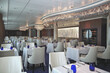 © Tamme Wichmann - Formal and elegant ocean view a la carte dining room restaurant onboard luxury cruiseship cruise ship liner with set tables in white and blue Art Deco interior design style ceiling ambient lighting