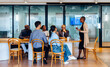 © (JLco) Julia Amaral - Group of diverse professionals engaging in discussion at a shared office table
