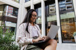 © Westend61 - Woman using laptop for remote work or study outdoors in city