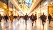 © hela - Blurred view of shoppers in a bright mall with glowing lights, suggesting holiday shopping or a busy retail space
