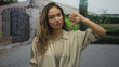 © Krakenimages.com - Woman outdoors making a thumbs-down gesture with a disapproving expression against an outdoor backdrop, conveying negativity in a casual setting.