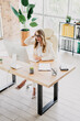 © deagreez - Young professional businesswoman working at a modern office desk with elegance and confidence