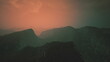 © icetray - Layers of rugged mountains stretch across the horizon, bathed in warm hues as the sun sets. A mystical atmosphere envelops the scene, creating an enchanting view of nature.