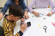 © Antonio Recena - Ten-year-old boy doing math homework with calculator beside his mother and sister at home