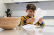 © Antonio Recena - Little boy making paper crafts at home kitchen table