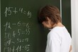 © New Africa - Back to school. Upset boy near chalkboard with math assignment indoors
