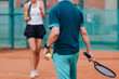 © tsuguliev - Tennis tournament championship on outdoor clay court with net, professional athletes play in motion with rackets serve tennis ball during tennis match game, tennis training in a sunny day on a stadium