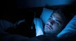© ArtFocus Studio - Man in bed at night using a mobile phone. A close-up shot of someone dealing with insomnia. Digital addiction, mental health, technology overuse.