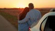 © Victoriia - Man woman hug enjoying sunset next to car on road. Happy family. Man woman couple standing hugging enjoying car trip out of town. People travel by car, leading active lifestyle in nature on vacation