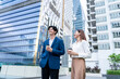 © Kawee - Asian young businessman and woman partner standing outdoors in the city.
