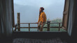 © Farknot Architect - A woman sitting on wooden balcony with mountain views on foggy morning outside the window