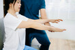 © Nuttapong punna - Healthcare professional helping patient with arm rehabilitation exercise, showing injury recovery, physical therapy care