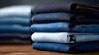 © Gulnaz - A stack of blue jeans on a wooden table