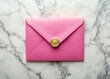 © Naowarat - Elegant pink envelope with seal and gold foil details on a marble background