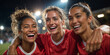 © OlenaSpark - Three female soccer players (european, african-european, asian) celebrating goal with joy and hugs on a brightly lit evening stadium, red jerseys and white shorts, emotional faces