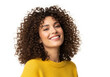 © Dani - A young woman with curly hair smiles brightly, wearing a yellow sweater against a white background.