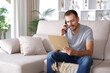 © Antonioguillem - Man reading document and consulting on phone at home