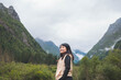 © suparat1983 - happy woman tourist trekking at mountain in Changping valley near Siguniang mountain in Sichuan province, China, color effect, low key and soft focus.