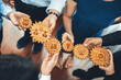 © InfiniteFlow - A diverse team collaborates effectively, holding wooden gears that symbolize creativity, growth, and analytics, emphasizing teamwork and strategic business planning. Amity