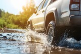 A silver pickup truck crossing a shallow stream water splashing around the tires under warm sunlight with clear space