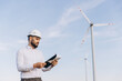 © anatoliycherkas - Engineer inspecting wind turbines for sustainable energy production