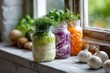 © matucha12 - Mason jars with homemade fermented vegetables and fresh herbs on windowsill, healthy eating