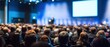 © Studio Nova - The audience at a corporate conference listening attentively to a presenter on stage