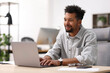 © New Africa - Man working on laptop at table in office