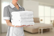 © New Africa - Chambermaid with clean towels in hotel room, closeup