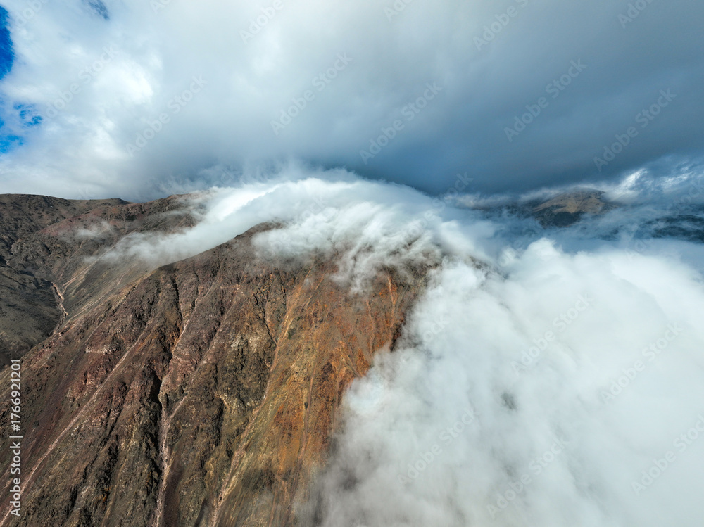 Close aerial of a mountain ridge with visible red and brown rock ...