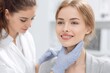 © YanabY - Woman receiving a skin treatment in a modern clinic setting with a skilled professional attending to her needs