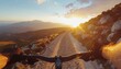 © HendrikusOktavianus - First-person view of a person riding a mountain bike on a dirt road at sunset