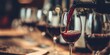 © Vivid_Vision - Red wine being poured into glass at wine tasting