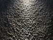 © TMR Studio - Close up of black textured paint with spot light effect on the surface. Rough textured paint is commonly used for exterior wall finishes in architecture. Seamless background texture.