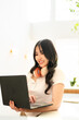 © Fahng - asian woman in casual using laptop sit alone at table in coffee shop cafe restaurant indoors work or study. Freelance mobile office business concept.